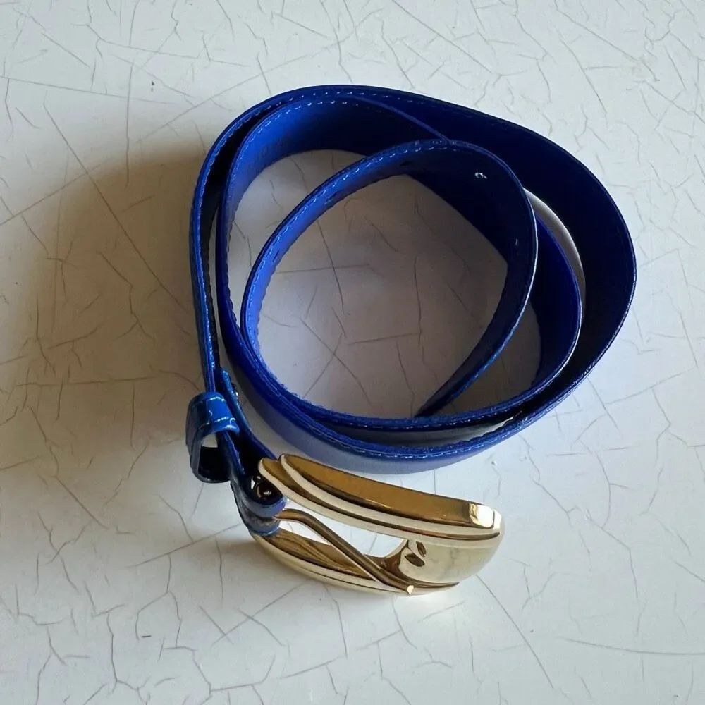 This royal blue patent leather belt from features a polished gold buckle